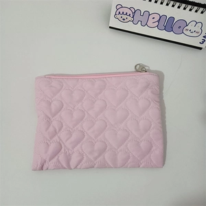 Detail of pink quilted heart texture cosmetic pouch with durable silver metal zipper closure