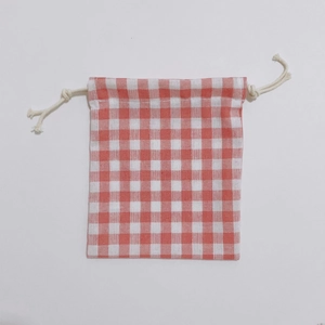 Detailed view of red and white checkered drawstring bag with cotton cord closure