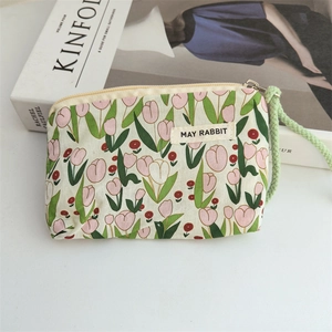 Detail of floral tulip canvas pouch featuring May Rabbit label and green wrist strap
