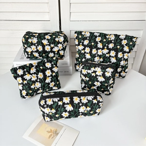 Detail of five-piece black canvas organizer set with white daisy embroidery accents