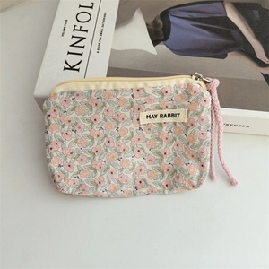 Detailed macro view of a floral cotton coin purse with a pink rope zipper puller