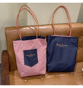 Dettaglio di borse tote in denim e quadri rossi con manici intrecciati colorati e ricami