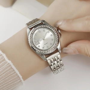 Détail de la montre à quartz argentée avec étoiles en strass et chiffres romains sur le cadran