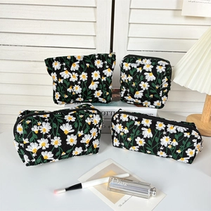 Set of four black cosmetic bags with daisy embroidery and smooth zipper closure