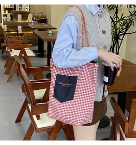 Dettaglio della borsa in tela a scacchi rossi con tasca in denim e ricamo Fantasy