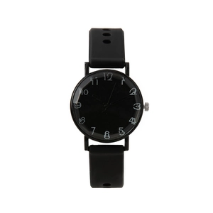 Détail d'une montre à quartz noire minimaliste avec bracelet en silicone et chiffres blancs