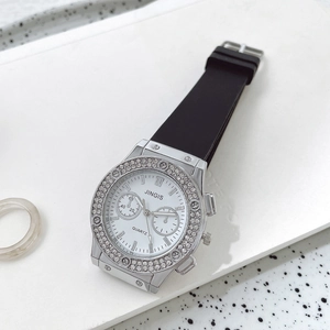 Détail de la montre argentée JINGIS avec lunette sertie de diamants et bracelet en silicone