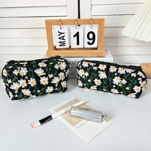 Close-up of daisy embroidery on high-quality black fabric travel cosmetic bags