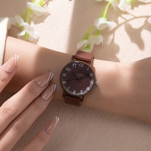 Gros plan d'une montre rétro marron avec chiffres artistiques sur fond texturé