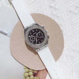 Détail de la lunette en strass argentés et du cadran noir sur la montre en silicone blanc