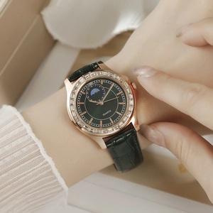 Montre femme élégante or rose avec bracelet cuir vert et lunette strass au poignet