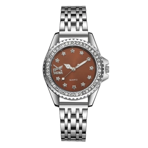 Détail d'une montre en acier argenté avec cadran étoilé et lunette en strass