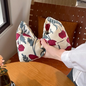 Close-up of floral canvas toiletry bag with red poppy print and secure zipper closure