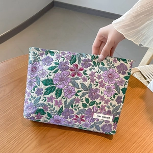 Detail of floral jacquard makeup bag with a handle and MAY RABBIT woven label