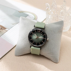 Detail of light green quartz watch with faceted glass and rose gold dial accents