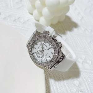 Gros plan de montre quartz argentée avec lunette sertie de diamants et bracelet blanc