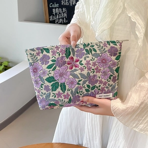 Detail of purple floral jacquard makeup bag showing rich texture and zip closure