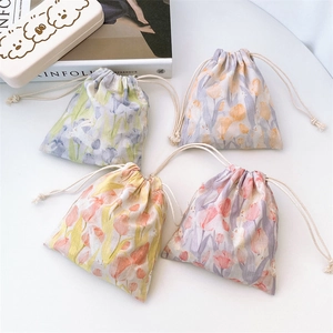 Detail view of four cotton drawstring bags featuring elegant tulip floral art prints