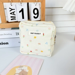 Detail of floral fabric storage pouch with zipper and MAY RABBIT label on desk