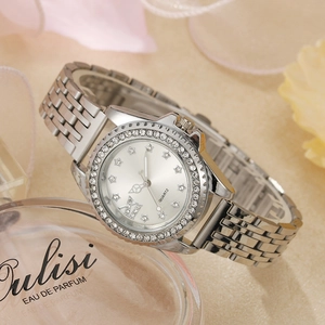 Détail du cadran argenté avec index en étoile et lunette en cristal sur montre à quartz