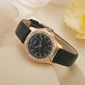 Détail d'une montre en cuir vert avec lunette en zircon or rose et cadran phase de lune