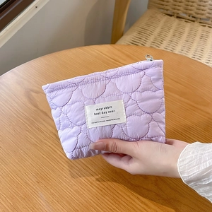 Detailed view of lavender quilted bear makeup bag with silver zipper and woven label