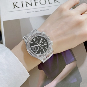Gros plan d'une montre à bracelet en silicone blanc avec lunette en strass sur magazine