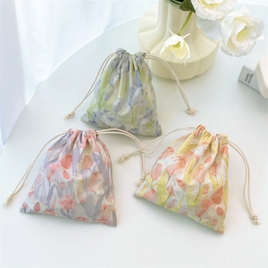Three tulip print drawstring jewelry bags in lavender, orange, and green floral designs