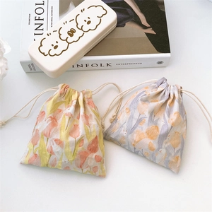 Floral tulip canvas drawstring pouch set with cute cartoon dog storage box on a desk