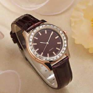 Nahaufnahme einer Luxus Damen Quarzuhr mit Roségold Diamant Lünette und Lederarmband
