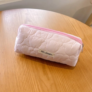 Detail of pink quilted bear pattern pencil case with MAY RABBIT label on wooden desk