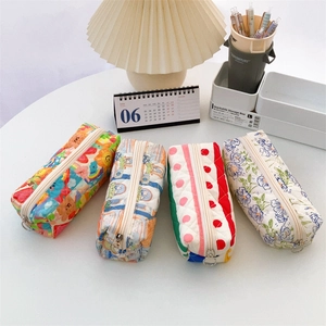Close-up of quilted floral pencil cases featuring various patterns and ring zipper pulls