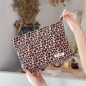 Close-up of leopard print corduroy makeup bag with a black zipper and May Rabbit label