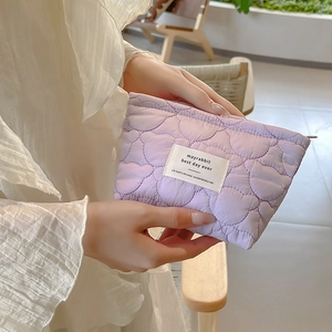 Detailed close-up of light purple quilted cosmetic bag with cute bear stitching pattern