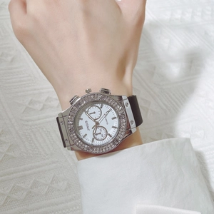 Gros plan d'une montre à quartz pour homme avec lunette en strass et bracelet en silicone noir