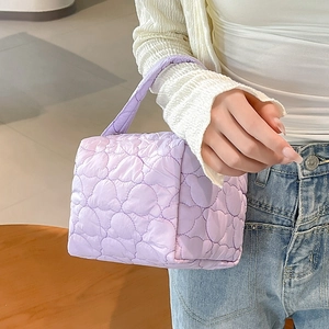 Detail of lavender quilted puffer bag featuring unique heart-shaped stitching pattern