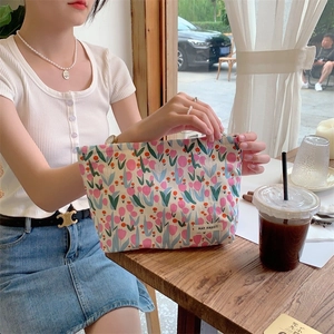 Floral cotton makeup bag with May Rabbit label shown in a cafe window setting