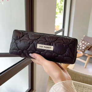 Detail of black quilted pencil case with heart texture and MAY RABBIT label