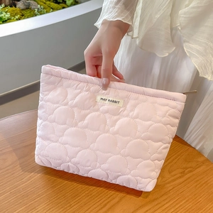 Detailed close-up of quilted pink makeup bag with May Rabbit label and cloud texture