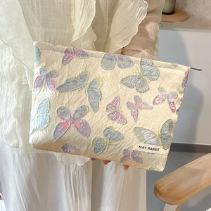 Detailed view of floral butterfly embroidery on high-capacity jacquard cosmetic bag