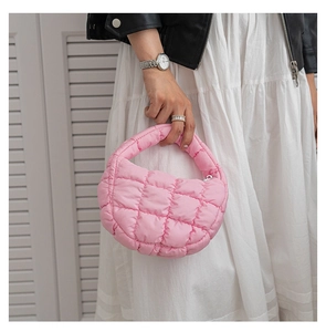 Sac à main rose matelassé avec texture bouffante en nylon porté par un mannequin
