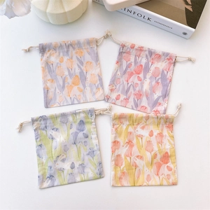 Flat lay of four colorful tulip and rabbit drawstring jewelry pouches on white surface