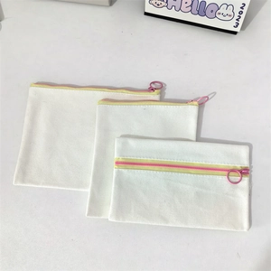 Three-piece set of white canvas pouches with yellow zip straps and pink pull rings