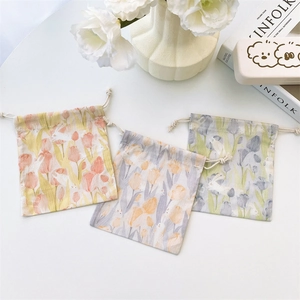 Detail view of cotton canvas drawstring jewelry bags with tulip and rabbit floral prints