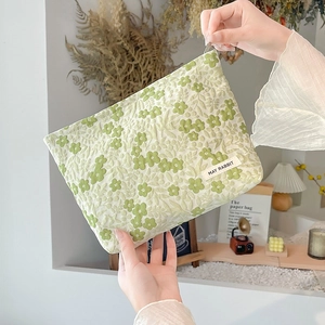Detail of floral embroidery on light green makeup bag with May Rabbit label
