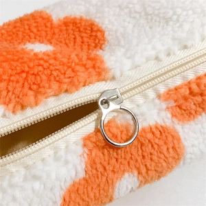 Close-up of sherpa floral pouch showing soft fleece texture and silver metal ring zipper