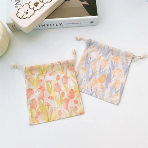 Detail of floral tulip and bunny print canvas drawstring jewelry bags on a white table