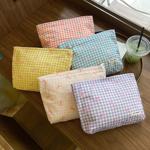 Dettaglio di cinque pochette per trucchi a quadretti con fiocchi in vari colori