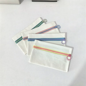 Detailed set of white canvas pouches with colorful zippers and metal ring pullers