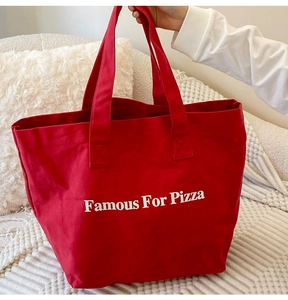 Nahaufnahme einer roten Canvas-Tasche mit Famous For Pizza-Druck auf weißem Hintergrund